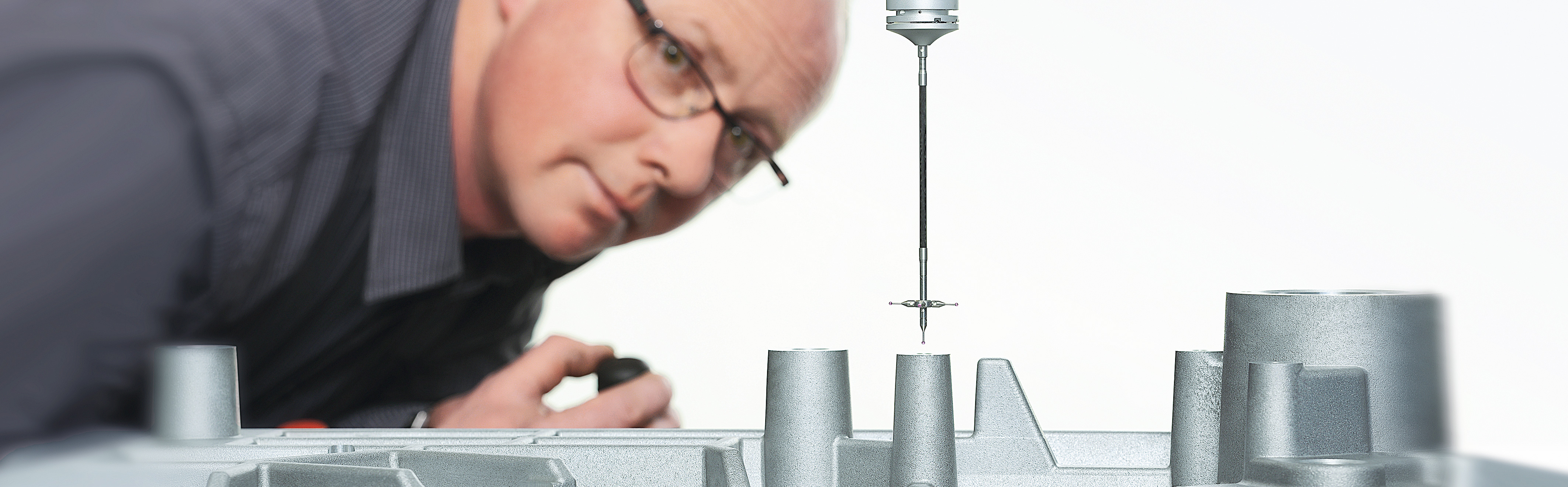 Detail of a measuring machine SAHM employee of the quality management looking at a part of a measuring machine